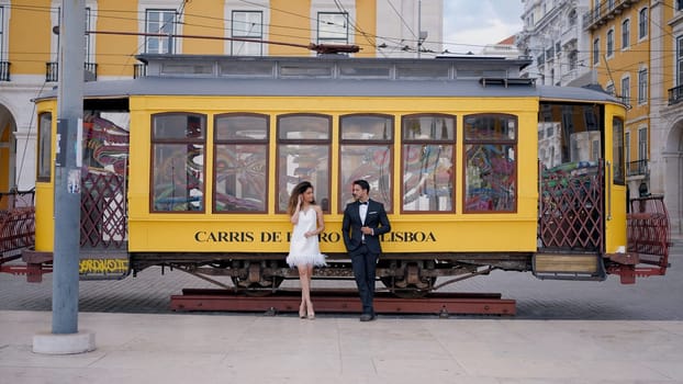 Lisbon-Portugal, 04.12.2022: Action. A young European tourist couple poses next to a statue of a bus. Use only for editorial. High quality 4k footage