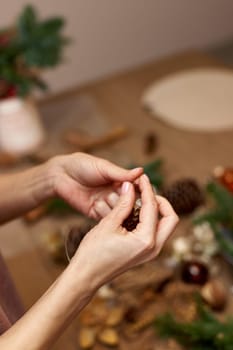 Woman making Christmas arrangement with fir branches. craft handmade decor.