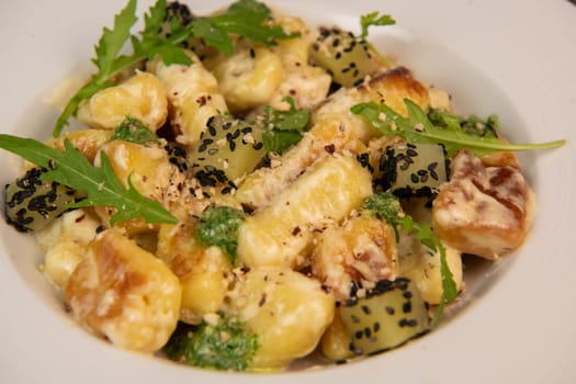 RECIPE FOR POTATO GNOCCHI WITH ROCKET SALAD PESTO AND CREAMY PARMESAN SAUCE. High quality photo