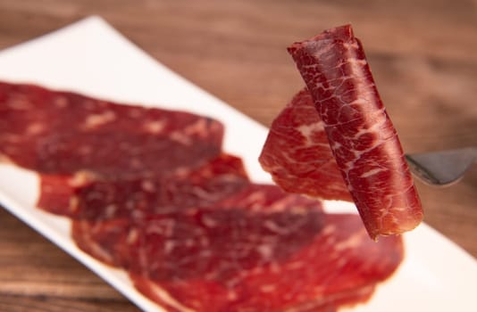 Dry-cured Spanish ham, Serrano ham, Bellota ham, Italian prosciutto crudo or Parma ham, wagyu slice. High quality photo