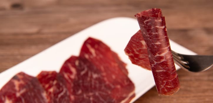 Dry-cured Spanish ham, Serrano ham, Bellota ham, Italian prosciutto crudo or Parma ham, wagyu slice. High quality photo