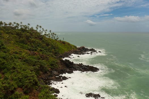 Seascape: Ocean waves roll on the rocky shore and beach. Travel concept. Secret Beach Mirissa, Sri Lanka.