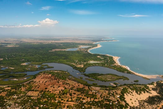 Aerial drone of coastline of Sri Lanka with the ocean and beaches, agricultural lands and towns.