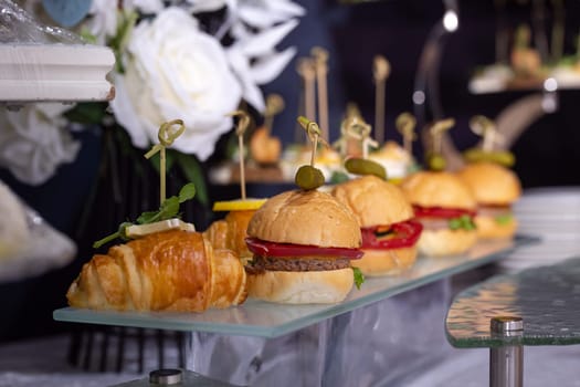 burgers on a stand on the buffet table.