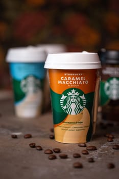 starbucks coffee in cups in assortment on the table with coffee beans