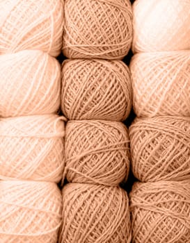 Color of the year 2024: Peach Fuzz.Selection of pastel colored yarn wool on shopfront. Knitting background, a lot of balls. Knitting yarn for handmade winter clothes