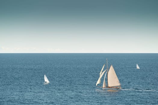 Monaco, lonely vintage sail yacht in sea at sunset, huge sail boat, wealth life of billionaires . High quality photo