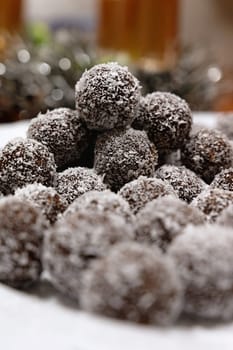 Rum balls in coconut. Traditional unbaked Czech sweets for Christmas and winter. Raw sweet food with cocoa and coconut.