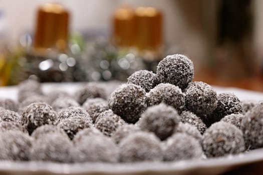 Rum balls in coconut. Traditional unbaked Czech sweets for Christmas and winter. Raw sweet food with cocoa and coconut.