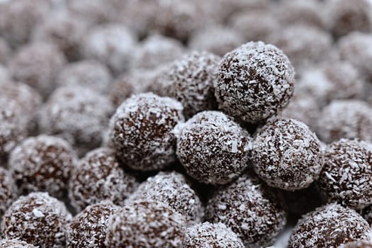 Rum balls in coconut. Traditional unbaked Czech sweets for Christmas and winter. Raw sweet food with cocoa and coconut.