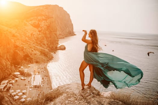 Woman sea trevel green dress. Side view a happy woman with long hair in a long mint dress posing on a beach with calm sea bokeh lights on sunny day. Girl on the nature on blue sky background