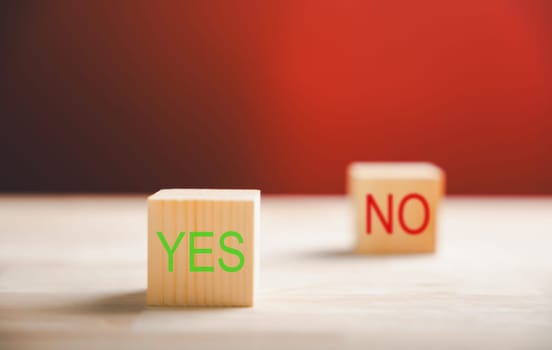 Decision-making concept portrayed by wooden block's green check mark and red x. Choice symbolism shown. Think With Yes Or No Choice.