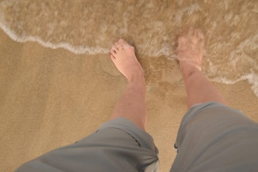 sea, water waves, yellow sand summer woman's legs in breeches. High quality photo