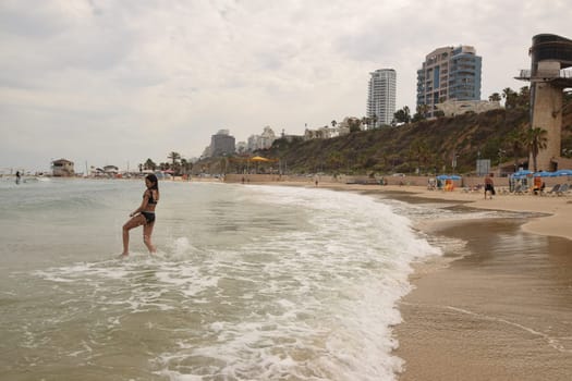20 June 2023 Netanya Israel, beach sand and sea water, women go,summer . High quality photo