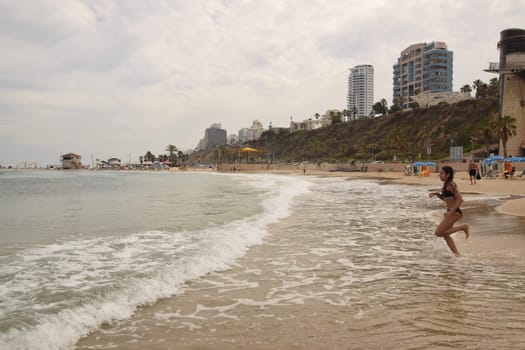 20 June 2023 Netanya Israel, beach sand and sea water, women go,summer . High quality photo