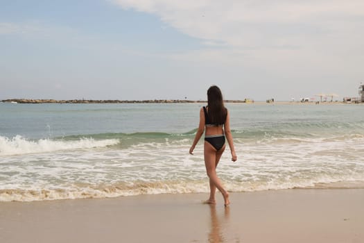 20 June 2023 Netanya Israel, beach sand and sea water, women go,summer . High quality photo