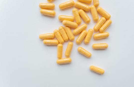 The image shows yellow capsules on a light grey background, suitable for healthcare and pharmaceutical themes