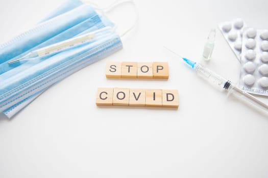 Stop coronavirus inscription. Preparing for vaccination against covid-19. Syringe, vaccine, pills, medical mask. A new strain of the virus
