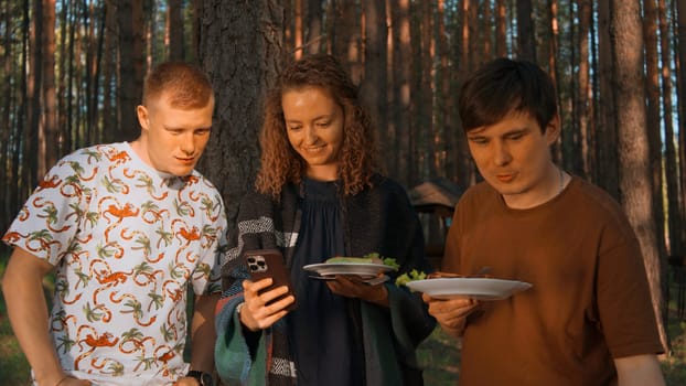 Young adult friends spending time outdoors in autumn forest. Stock footage. Barbeque with friends
