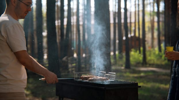 Young adult friends spending time outdoors in autumn forest. Stock footage. Barbeque with friends