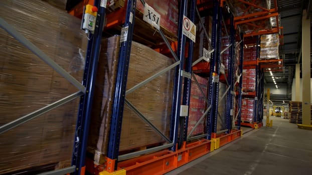 Moscow - Russia, 04.20.2022: Warehouse materials and metal shelves with goods inside cardbox boxes. Creative. The camera moves among the shelves with different boxes