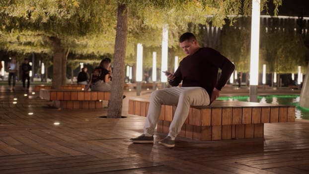 A man walking in the park. Stock footage. A young man walking through the dark streets and answering the phone. High quality 4k footage