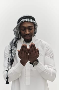 African American Muslim man raises his hands in prayer, seeking solace and devotion to God, as he stands isolated against a serene white backdrop, symbolizing a profound expression of faith and contemplation.