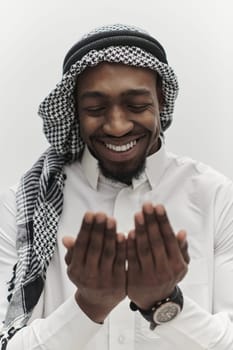 African American Muslim man raises his hands in prayer, seeking solace and devotion to God, as he stands isolated against a serene white backdrop, symbolizing a profound expression of faith and contemplation.