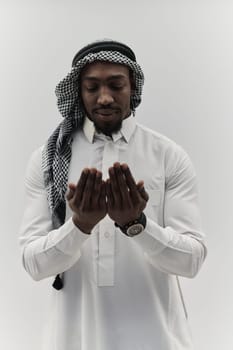 African American Muslim man raises his hands in prayer, seeking solace and devotion to God, as he stands isolated against a serene white backdrop, symbolizing a profound expression of faith and contemplation.