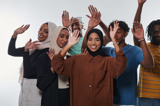 A jubilant and diverse group, including an African American man and hijab-wearing girls, exuberantly wave and celebrate, embodying the vibrancy of student life against a white backdrop, symbolizing unity, cultural diversity, and the joyous spirit of shared experiences.