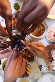 In a poignant close-up, the diverse hands of a Muslim family delicately grasp fresh dates, symbolizing the breaking of the fast during the holy month of Ramadan, capturing a moment of cultural unity, shared tradition, and the joyous anticipation of communal iftar.