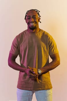 A charismatic and stylish African American man commands attention against a vibrant yellow gel background, showcasing his confident and contemporary fashion sense, radiating charm and sophistication in a striking portrait.