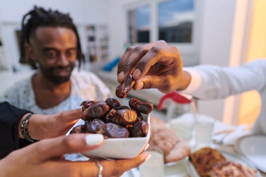 In a poignant close-up, the diverse hands of a Muslim family delicately grasp fresh dates, symbolizing the breaking of the fast during the holy month of Ramadan, capturing a moment of cultural unity, shared tradition, and the joyous anticipation of communal iftar.
