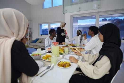 In the sacred month of Ramadan, a Muslim family joyously comes together around a table, eagerly awaiting the communal iftar, engaging in the preparation of a shared meal, and uniting in anticipation of a collective prayer, embodying the spirit of togetherness, devotion, and cultural celebration.