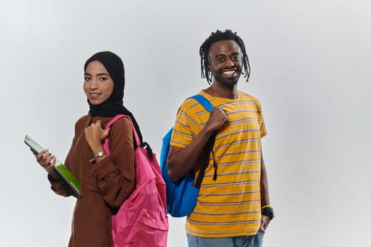 Against a clean white background, two students, an African American young man and a hijab-wearing woman, collaboratively use laptops in a display of technological empowerment and inclusive education, embodying the unity and diversity within the academic journey.