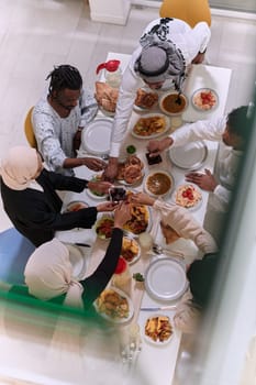 Top view of diverse hands of a Muslim family delicately grasp fresh dates, symbolizing the breaking of the fast during the holy month of Ramadan, capturing a moment of cultural unity, shared tradition, and the joyous anticipation of communal iftar.