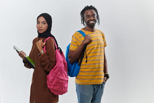 Against a clean white background, two students, an African American young man and a hijab-wearing woman, collaboratively use laptops in a display of technological empowerment and inclusive education, embodying the unity and diversity within the academic journey.