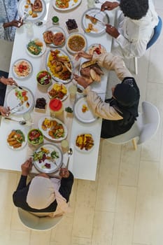 Top view of traditional and diverse Muslim family comes together to share a delicious iftar meal during the sacred month of Ramadan, embodying the essence of familial joy, cultural richness, and spiritual unity in their shared celebration.