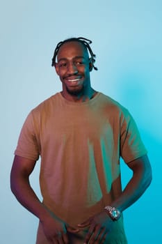 A confident and stylish African American man strikes a pose against a captivating blue gel background, showcasing his charismatic presence and contemporary fashion sense in a dynamic and vibrant portrait.