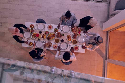 Top view of a Muslim family joyously comes together around a table, eagerly awaiting the communal iftar, engaging in the preparation of a shared meal, and uniting in anticipation of a collective prayer, embodying the spirit of togetherness, devotion, and cultural celebration.