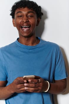 African American teenager engages with his smartphone against a pristine white background, encapsulating the essence of contemporary digital connectivity and youth culture.