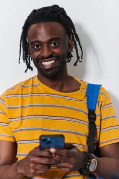 African American teenager engages with his smartphone against a pristine white background, encapsulating the essence of contemporary digital connectivity and youth culture.