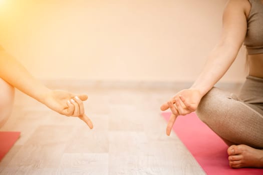 Two beautiful women do yoga, sports in the gym. The concept of grace and beauty of the body