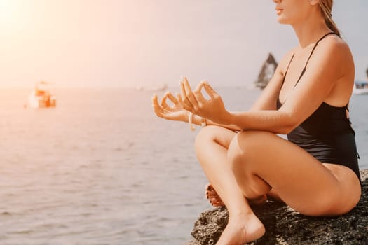 Woman sea yoga. Back view of free calm happy satisfied woman with long hair standing on top rock with yoga position against of sky by the sea. Healthy lifestyle outdoors in nature, fitness concept.