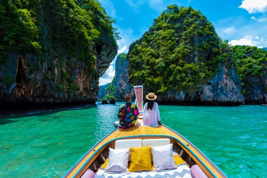 Luxury Longtail boat in Krabi Thailand, couple man, and woman on a trip at the tropical island 4 Island trip in Krabi Thailand. Asian woman and European man mid age on vacation in Thailand.