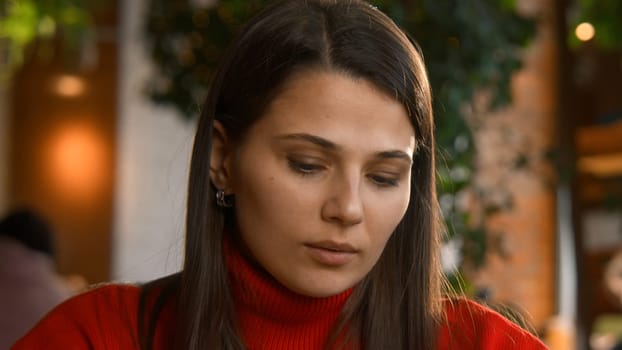 Close-up of woman typing on laptop. Stock footage. Beautiful young woman is typing novel on laptop in cafe. Young writer is writing novel on laptop.