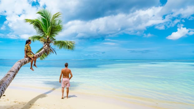 a couple of men and women on vacation at the beach of the Seychelles, men, and woman visit Anse Royale Beach in Mahe Island Seychelles