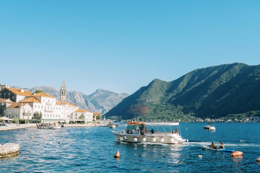 Excursion boat sails along the Bay of Kotor to the coast of Perast. Montenegro. High quality photo