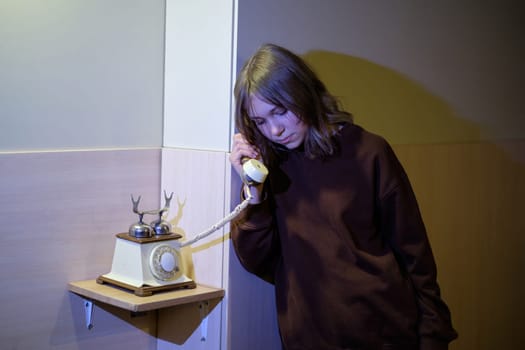 Sad teenage girl in transition is waiting for help on the phone