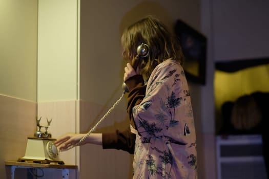 A teenage girl in an atmosphere of depression calls a wired phone in the hope of getting help from family, friends, and special social services